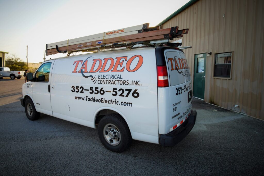 A white service van with Taddeo Electric's orange and black logo on the side.