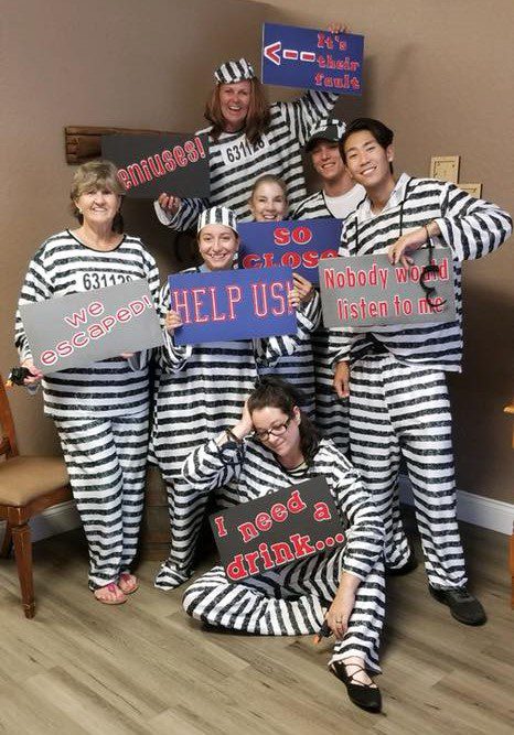 MG team dressed as prisoners for their escape room fun.