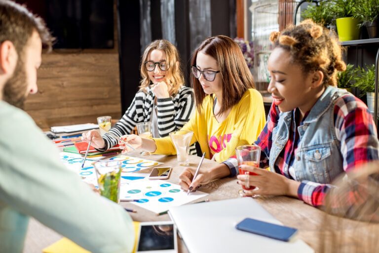 Small group of diverse team members working together at a table during a business strategy retreat.